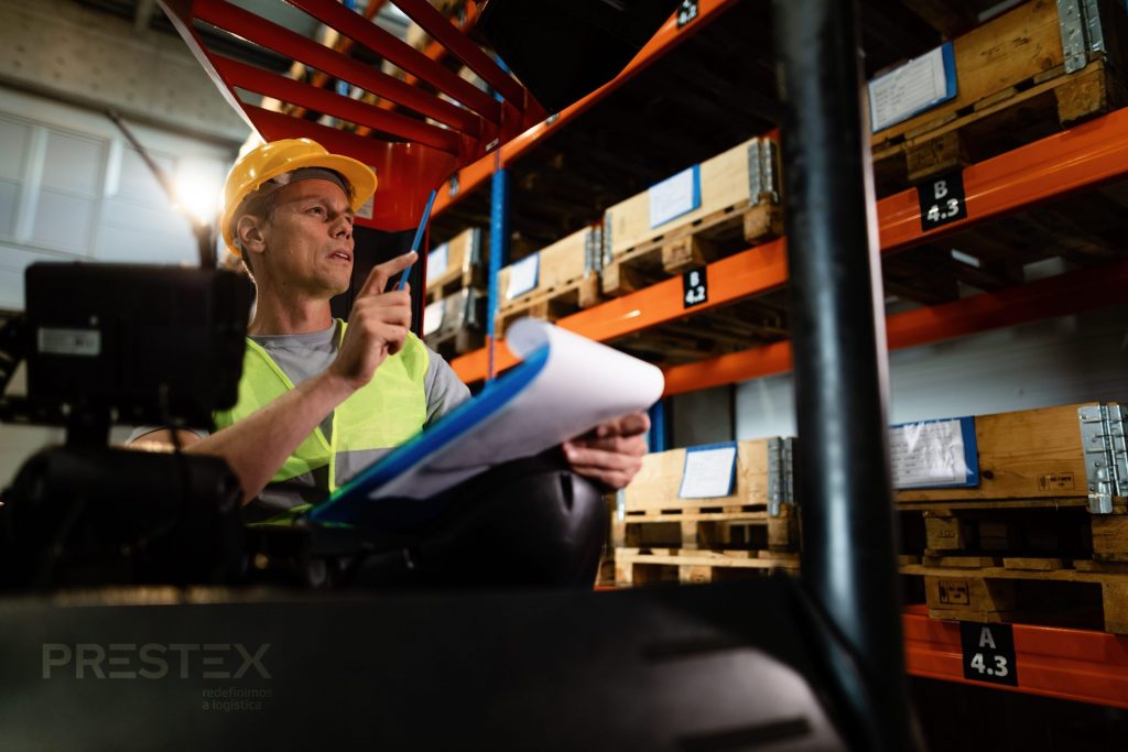 pensive forklift operator examining prestex stock packages shelves warehouse